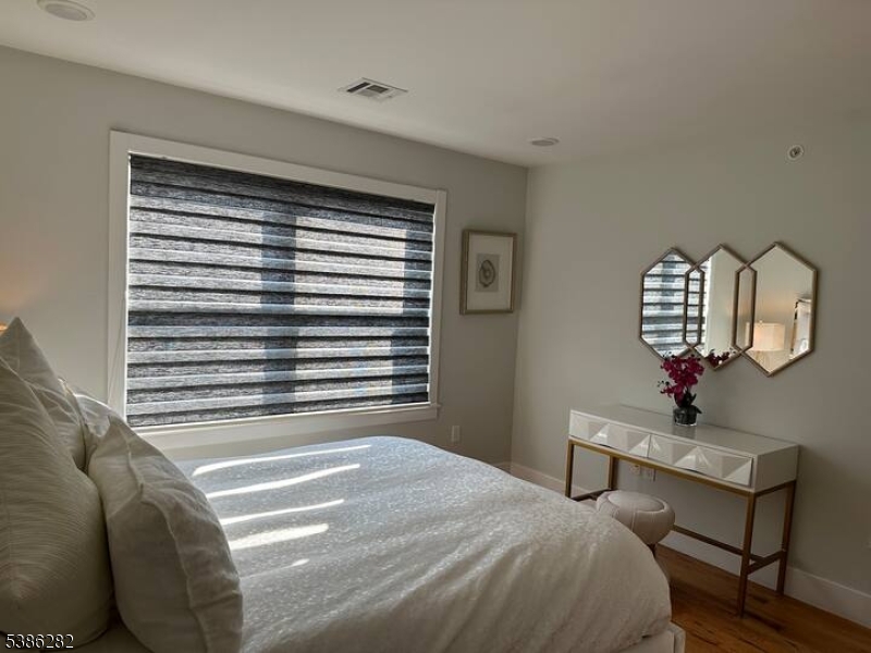 859 Main Street, Unit 40 Paterson, NJ 07503 - Photo 8 of 10 a bedroom with a bed a dresser and chair