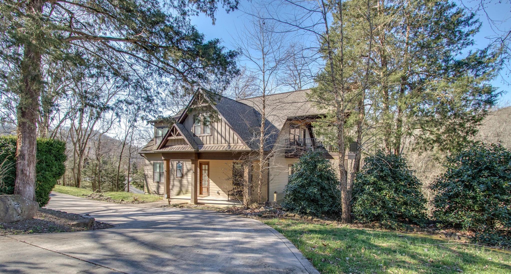 a front view of a house with garden and trees