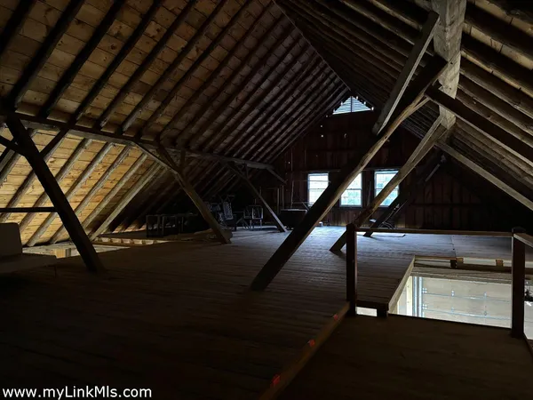 a kitchen with stainless steel appliances granite countertop a refrigerator a stove and a dining table with wooden floor