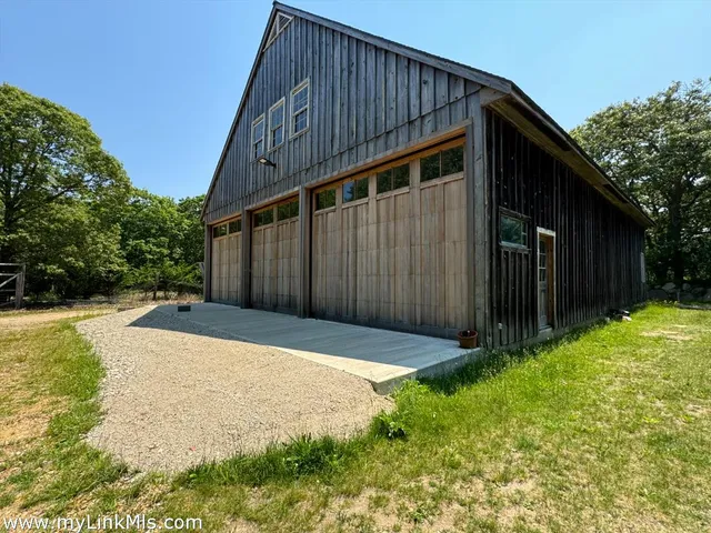 a backyard of a house with large trees and wooden fence