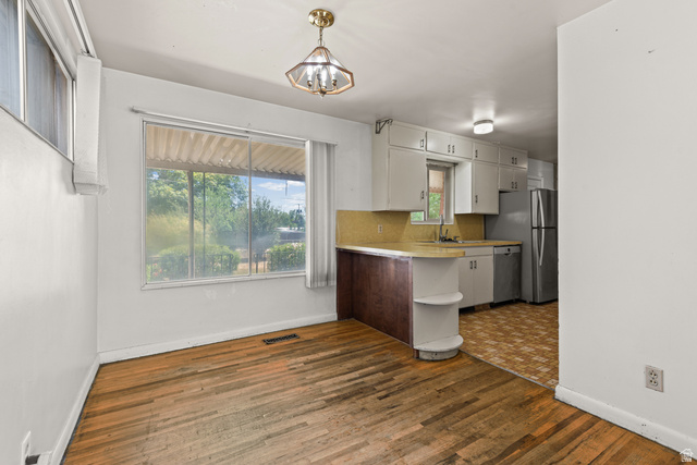 542 East 3400th Street North Provo, UT 84604 - Photo 11 of 39 Dining area with wood-finish flooring, a large window, and an overhead light fixture