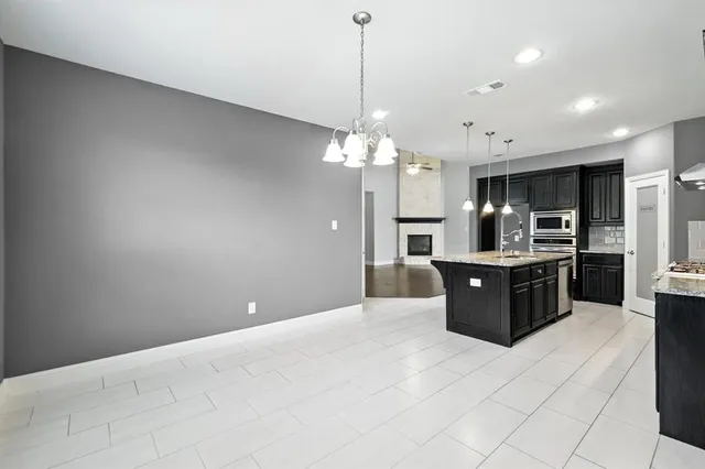 a large kitchen with a chandelier and refrigerator