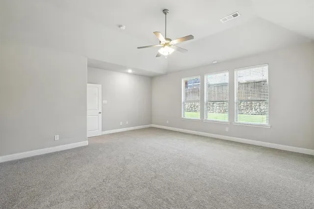 en empty room with windows and ceiling fan