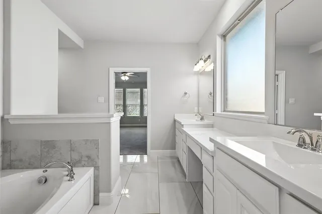 a bathroom with a tub sink and mirror