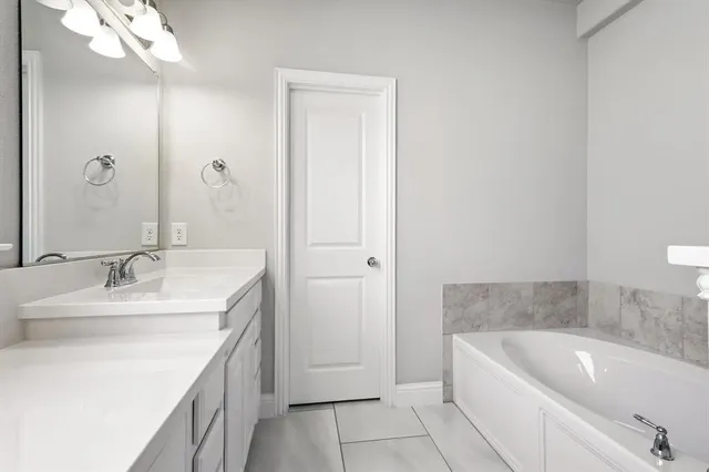 a bathroom with a tub sink and mirror