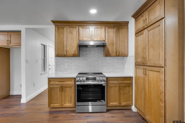 a kitchen with stainless steel appliances wooden floor sink and wooden cabinets