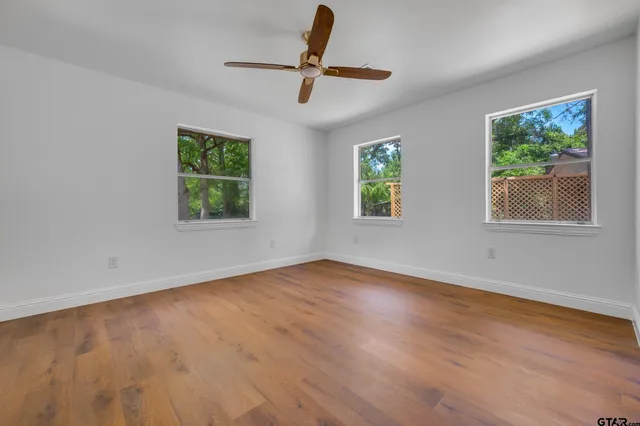 a view of room with hardwood floor and ceiling fan