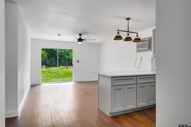 a view of a kitchen with a sink and dishwasher with wooden floor