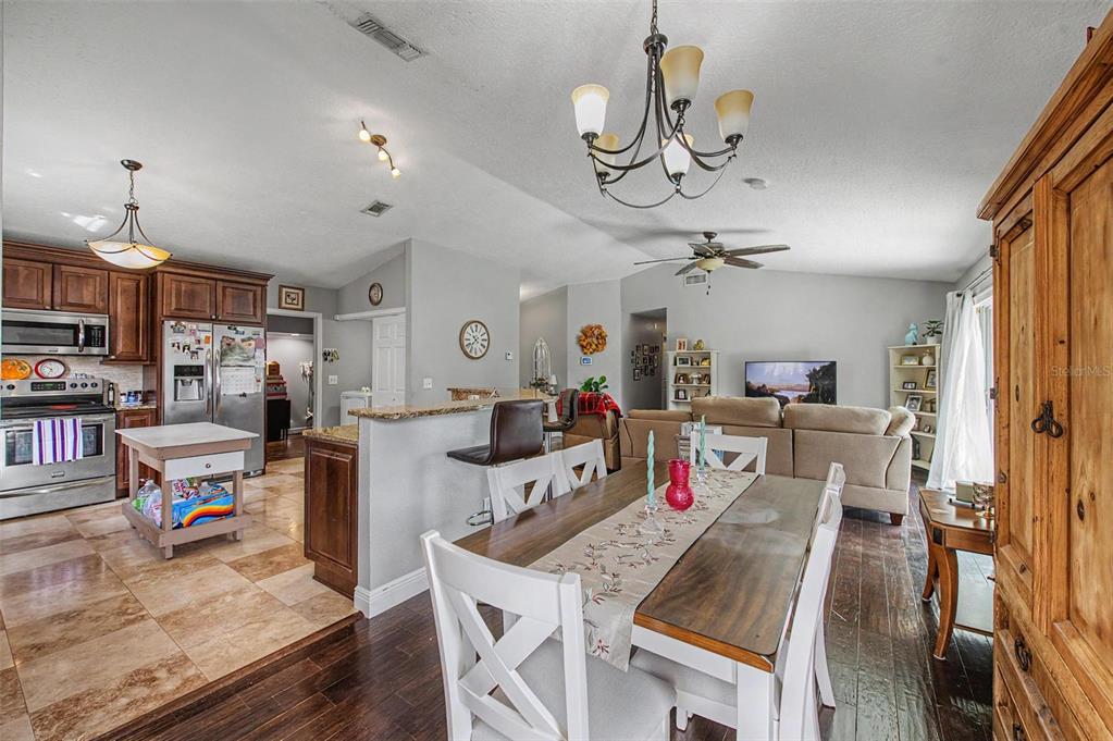 1632 Pintail Court Lutz, FL 33549 - Photo 11 of 34 a view of a dining room and livingroom with furniture wooden floor a chandelier