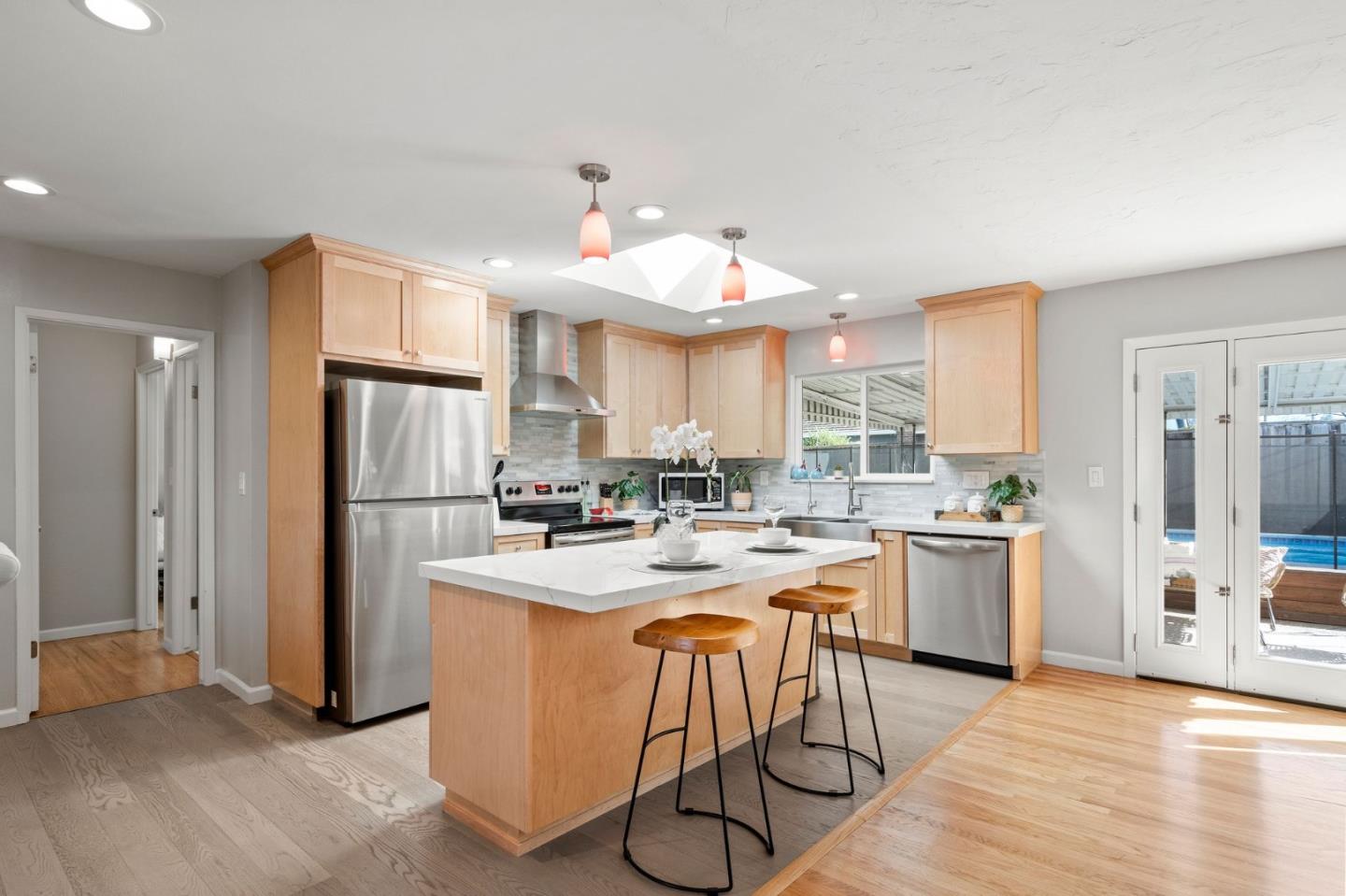 5074 Williams Road San Jose, CA 95129 - Photo 11 of 35 a kitchen with a refrigerator a stove a sink and a dining table with wooden floor