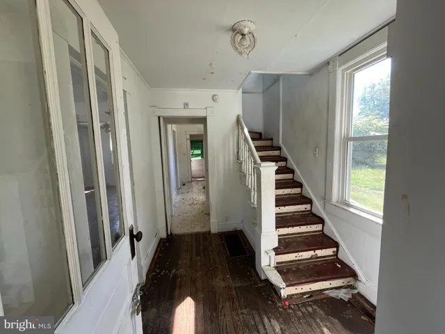 a view of a hallway with stairs and wooden floor