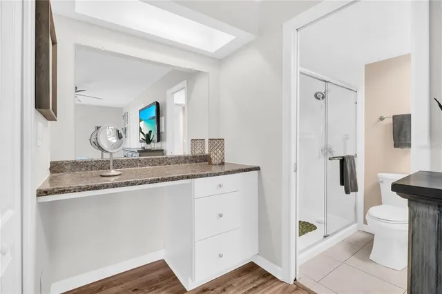 a bathroom with a granite countertop toilet sink and mirror