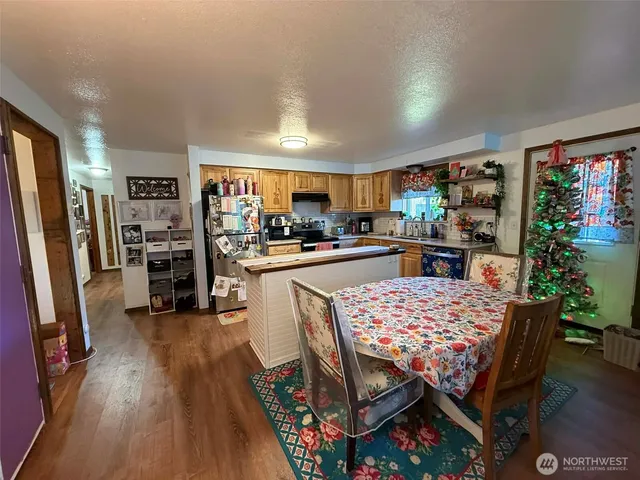 a kitchen with stainless steel appliances wooden floor dining table and chairs