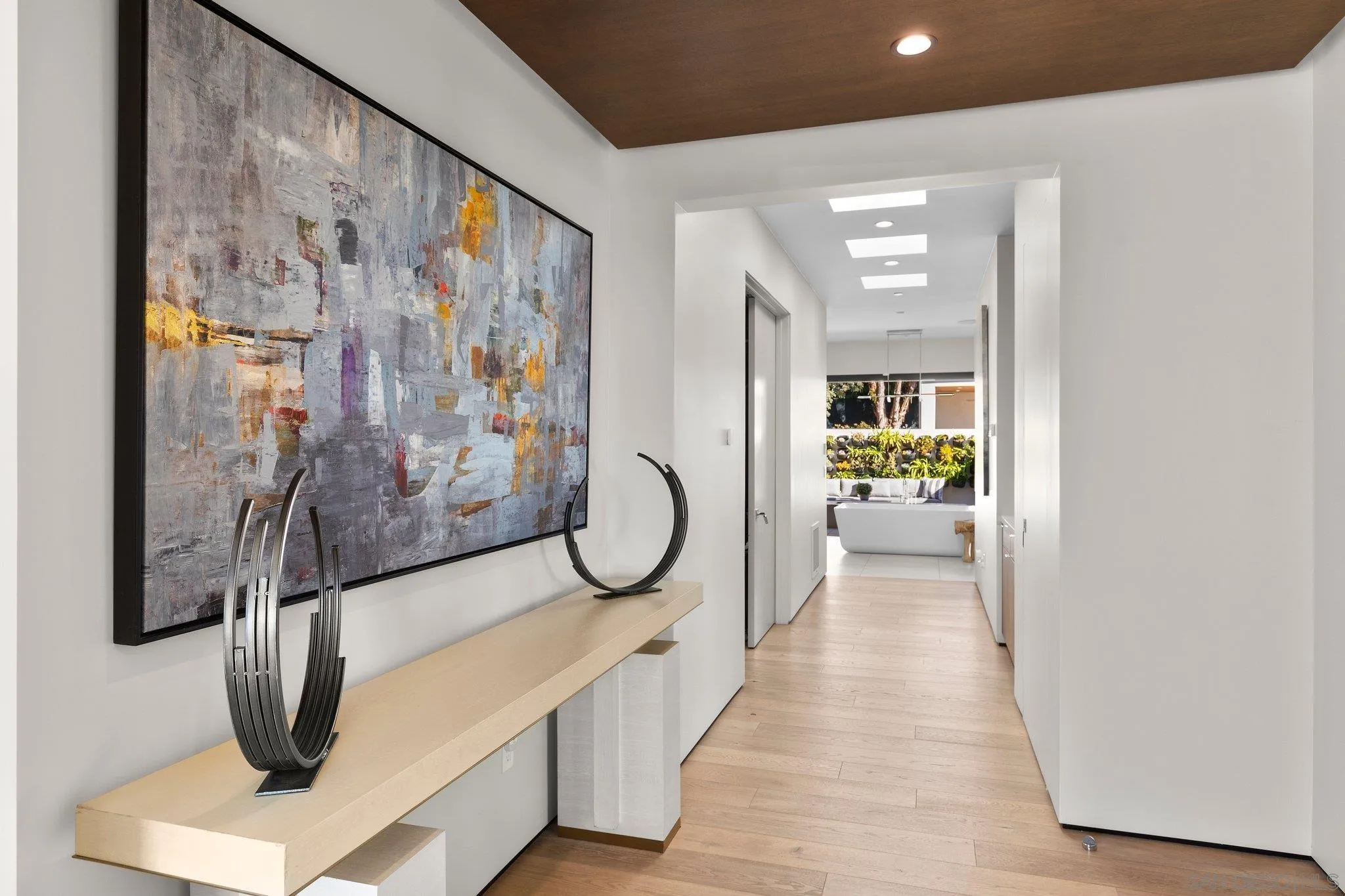 6349 Castejon Drive La Jolla, CA 92037 - Photo 23 of 43 a hallway with painting on the wall and a large mirror