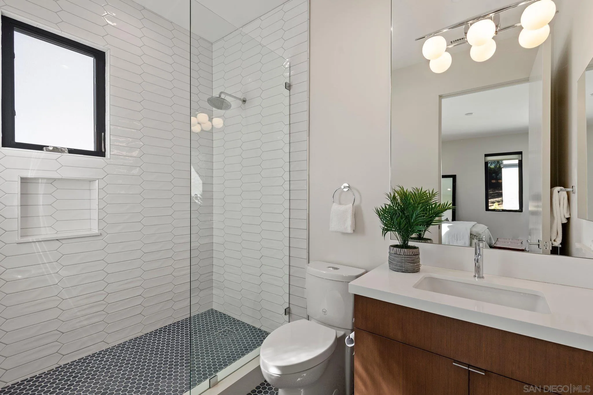 6349 Castejon Drive La Jolla, CA 92037 - Photo 35 of 43 a bathroom with a sink a toilet a mirror and shower