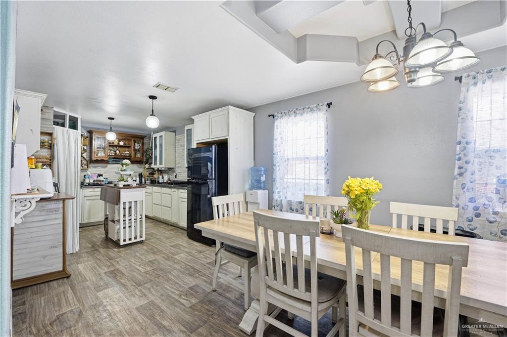 121 Jo Beth Street Alton, TX 78573 - Photo 3 of 12 a dining room with furniture a kitchen and chandelier
