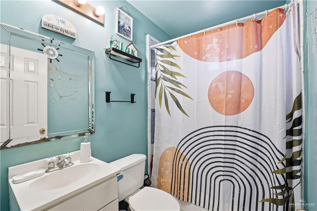 121 Jo Beth Street Alton, TX 78573 - Photo 6 of 12 a bathroom with a sink a mirror and a shower curtain