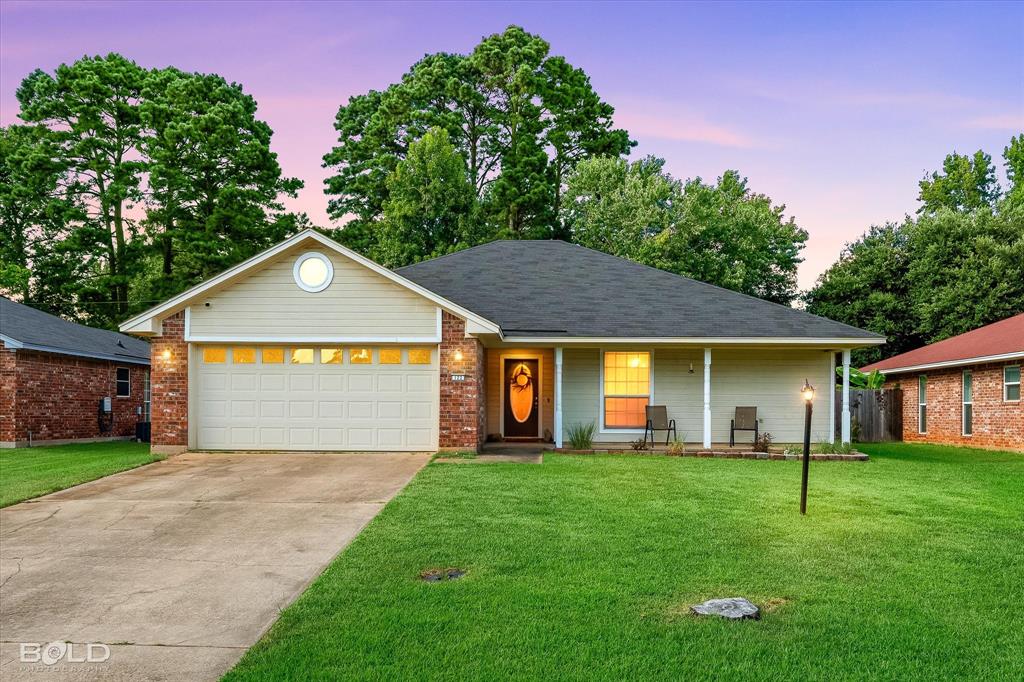 122 Ragan Lane Haughton, LA 71037 - Photo 1 of 34 Siding exterior with brick accents, attached garage, covered front porch, and a concrete driveway