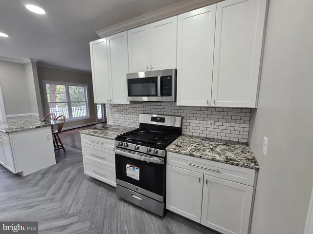 a kitchen with white cabinets and appliances