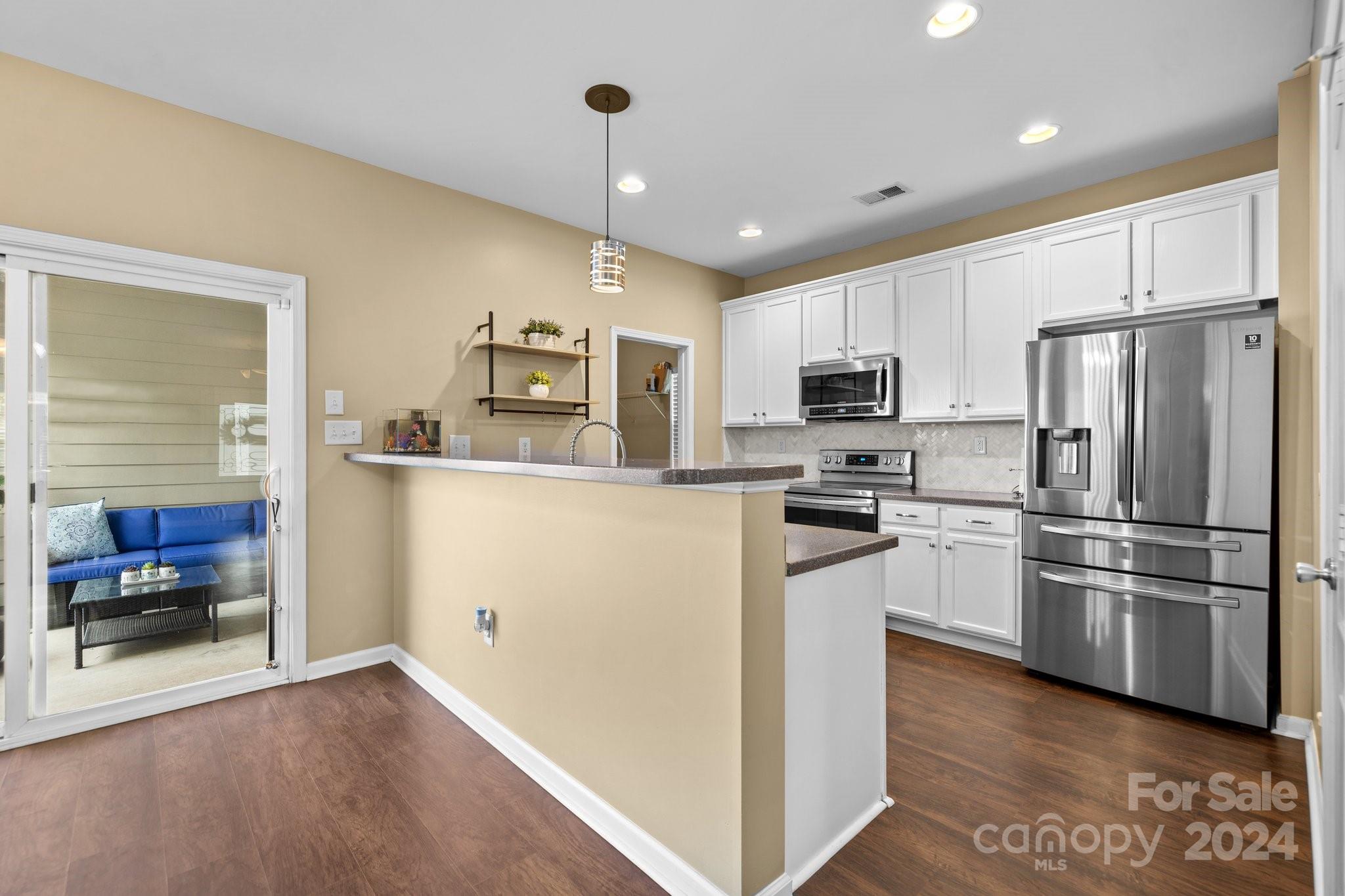 10231 Enniscrone Road Pineville, NC 28134 - Photo 14 of 44 a kitchen with granite countertop a refrigerator stove and microwave