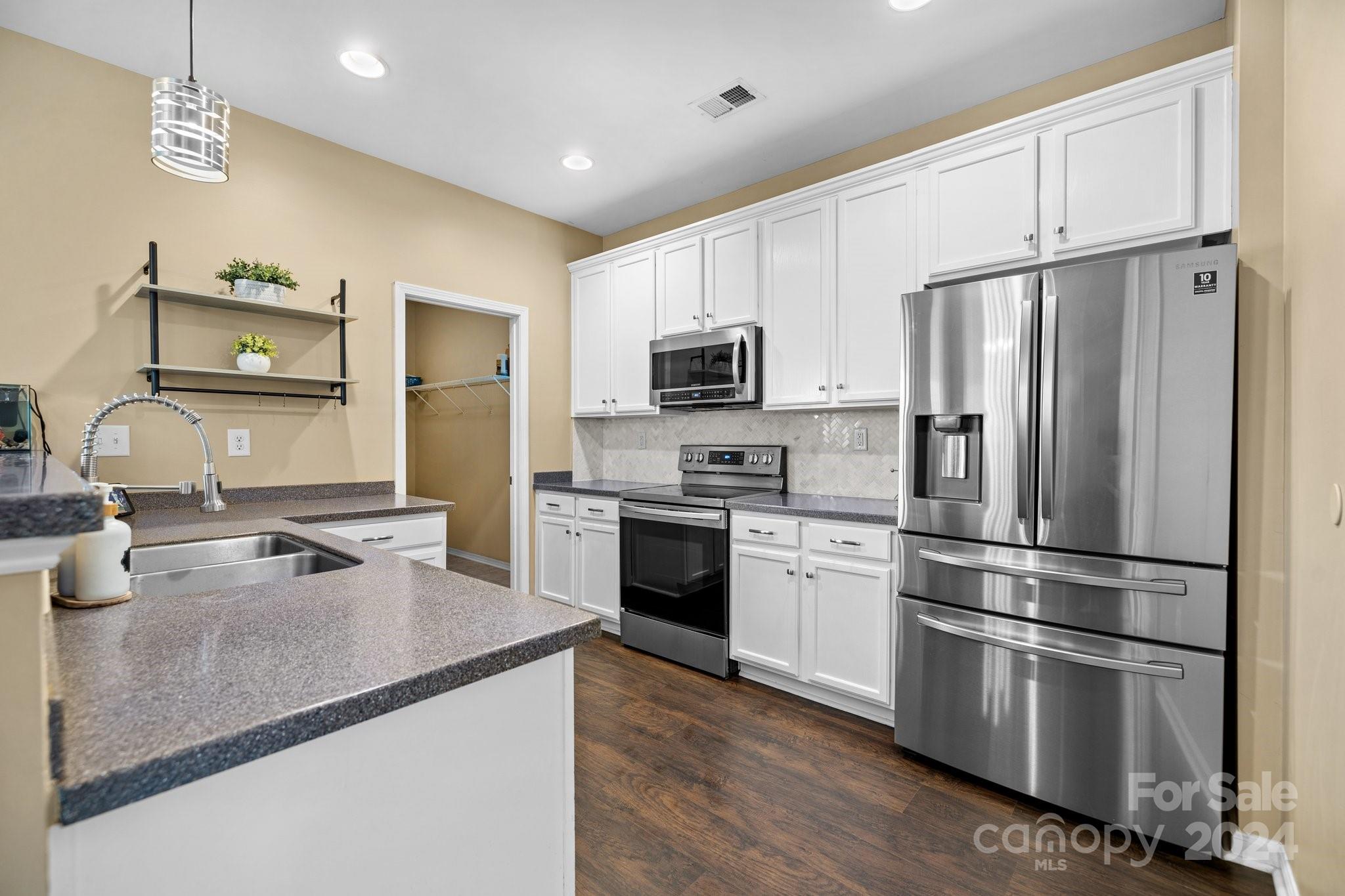 10231 Enniscrone Road Pineville, NC 28134 - Photo 15 of 44 a kitchen with granite countertop a refrigerator stove and sink