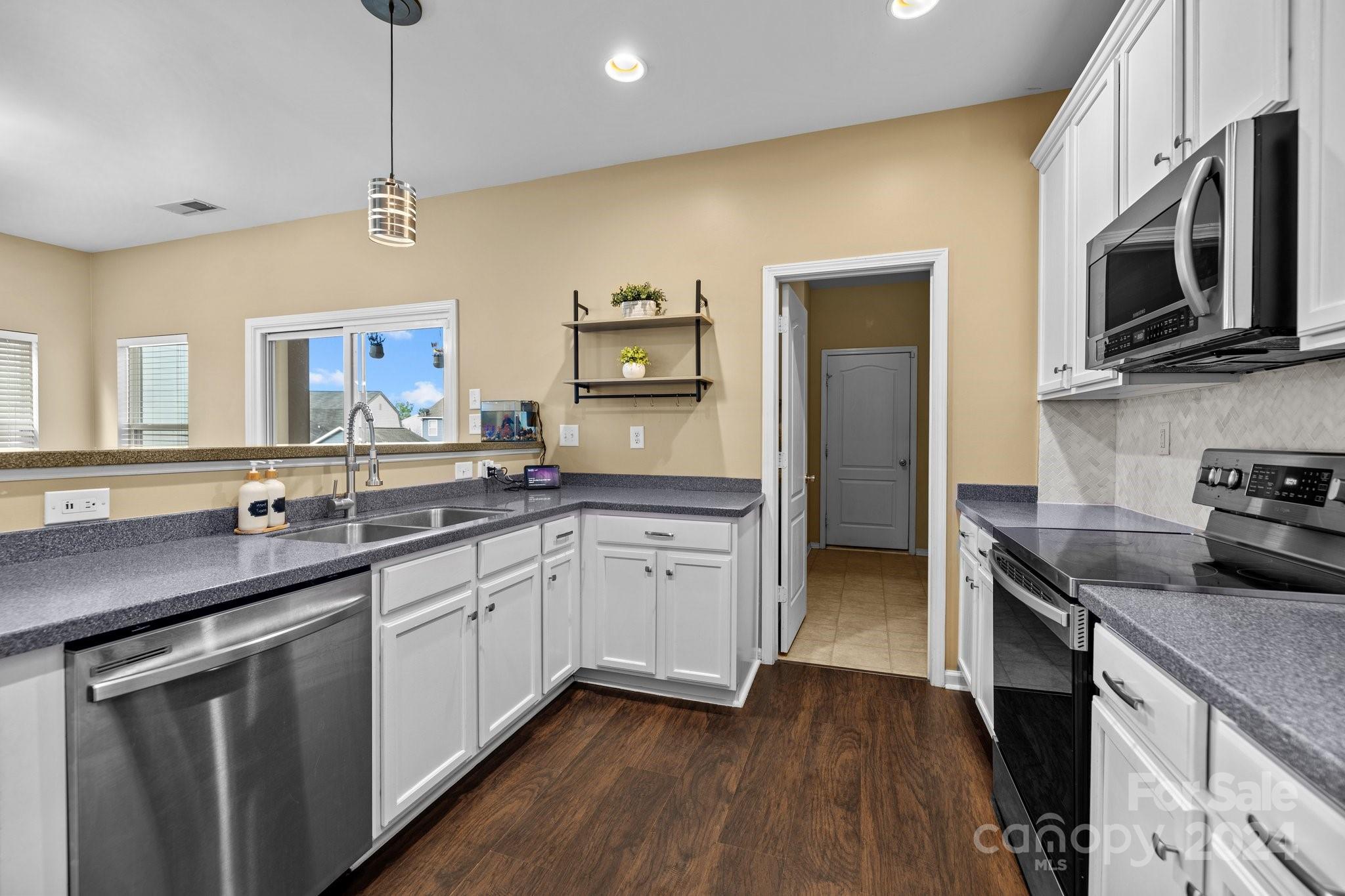 10231 Enniscrone Road Pineville, NC 28134 - Photo 16 of 44 a kitchen with a sink stove and microwave