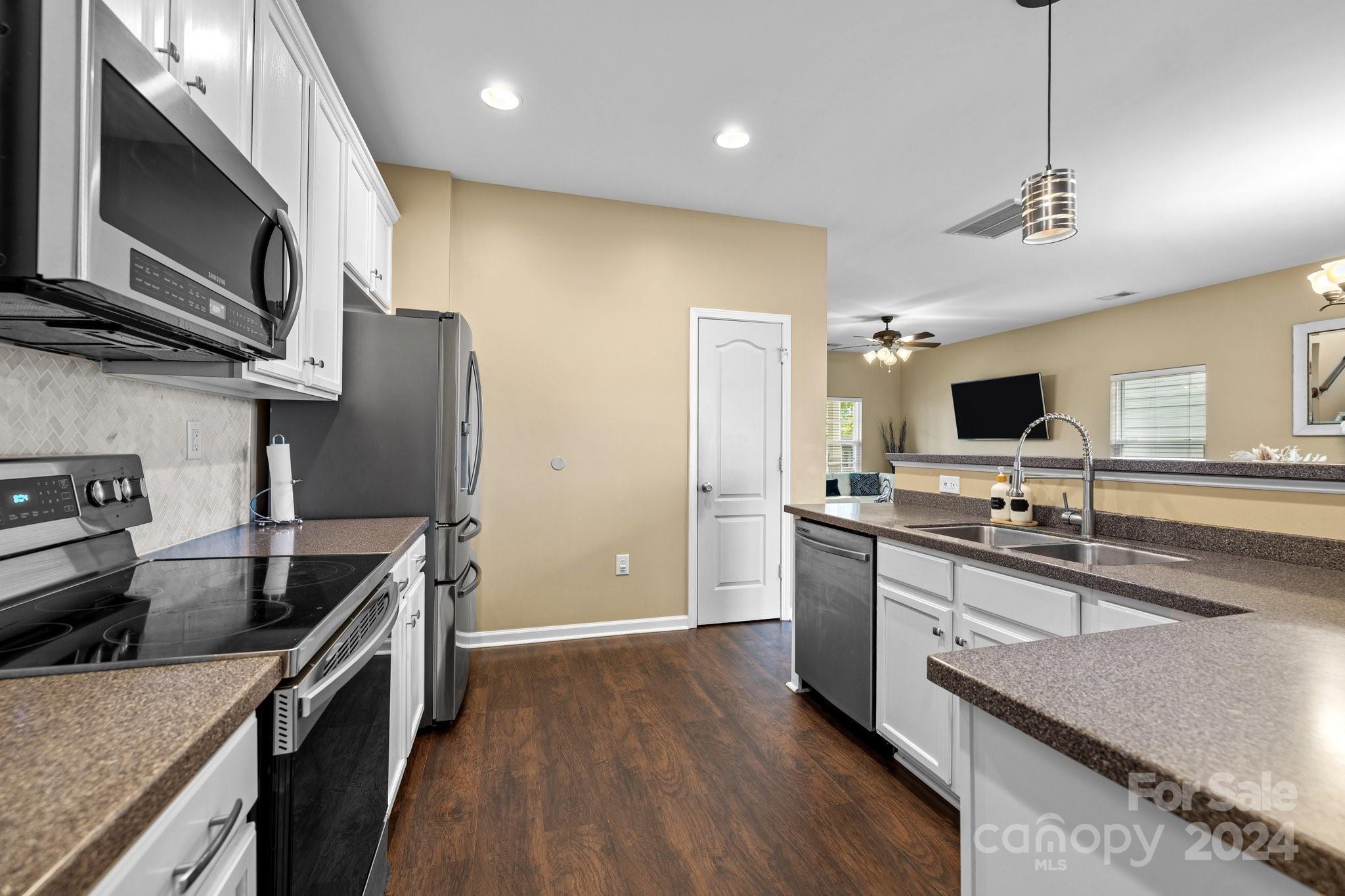 10231 Enniscrone Road Pineville, NC 28134 - Photo 17 of 44 a kitchen with stainless steel appliances granite countertop a sink stove and refrigerator