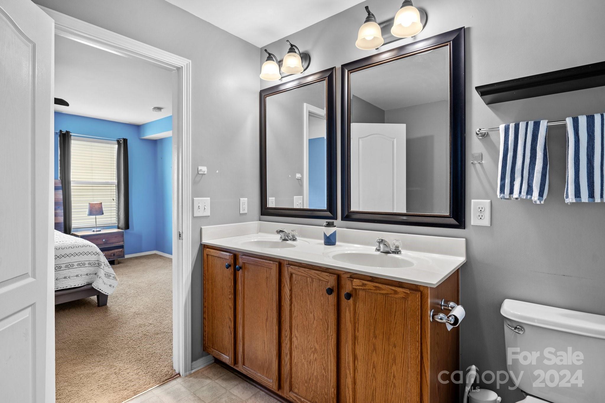 10231 Enniscrone Road Pineville, NC 28134 - Photo 32 of 44 a en suite bathroom with a double vanity sink and a mirror
