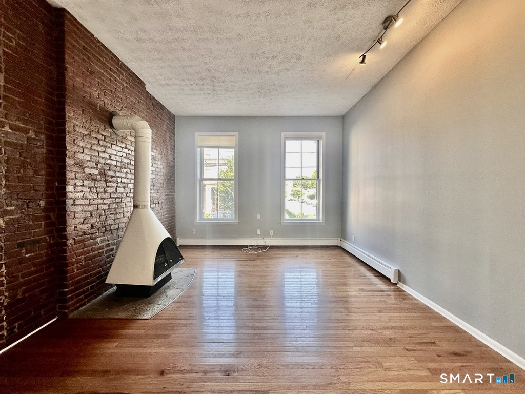 46 Warren Street New Haven, CT 06511 - Photo 3 of 10 an empty room with wooden floor and windows