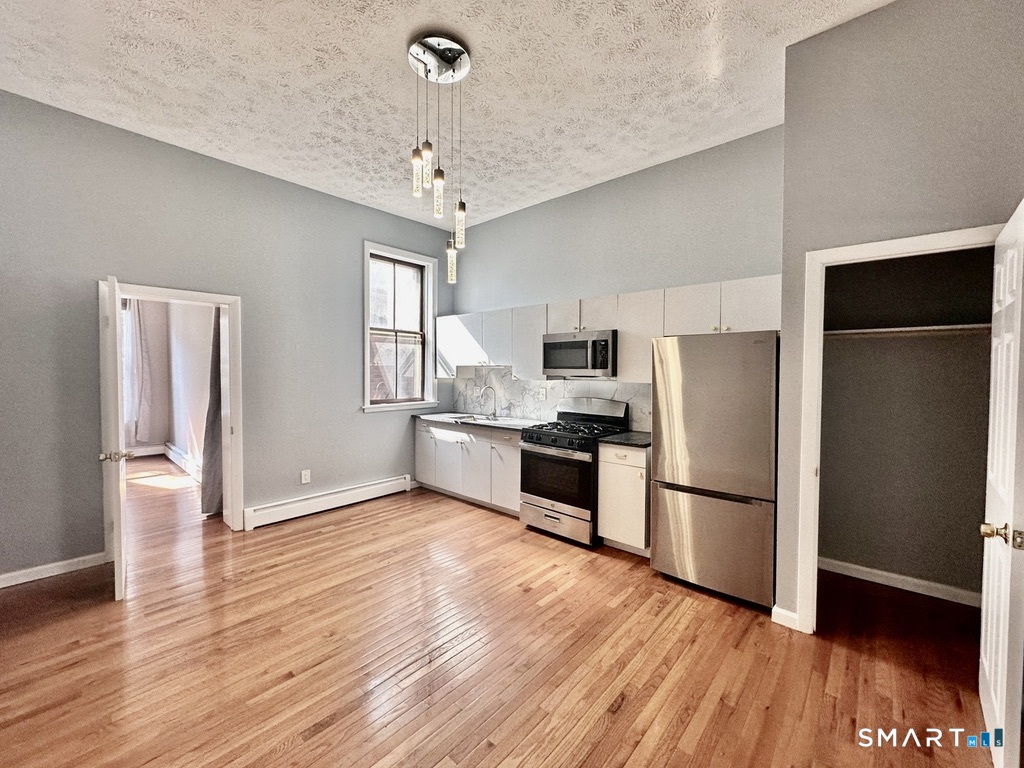46 Warren Street New Haven, CT 06511 - Photo 5 of 10 a kitchen with stainless steel appliances a refrigerator and wooden floor