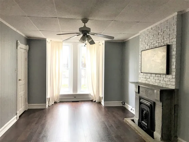 a view of a livingroom with wooden floor and a ceiling fan