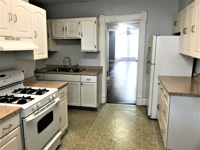 a kitchen with stainless steel appliances granite countertop a refrigerator and a stove
