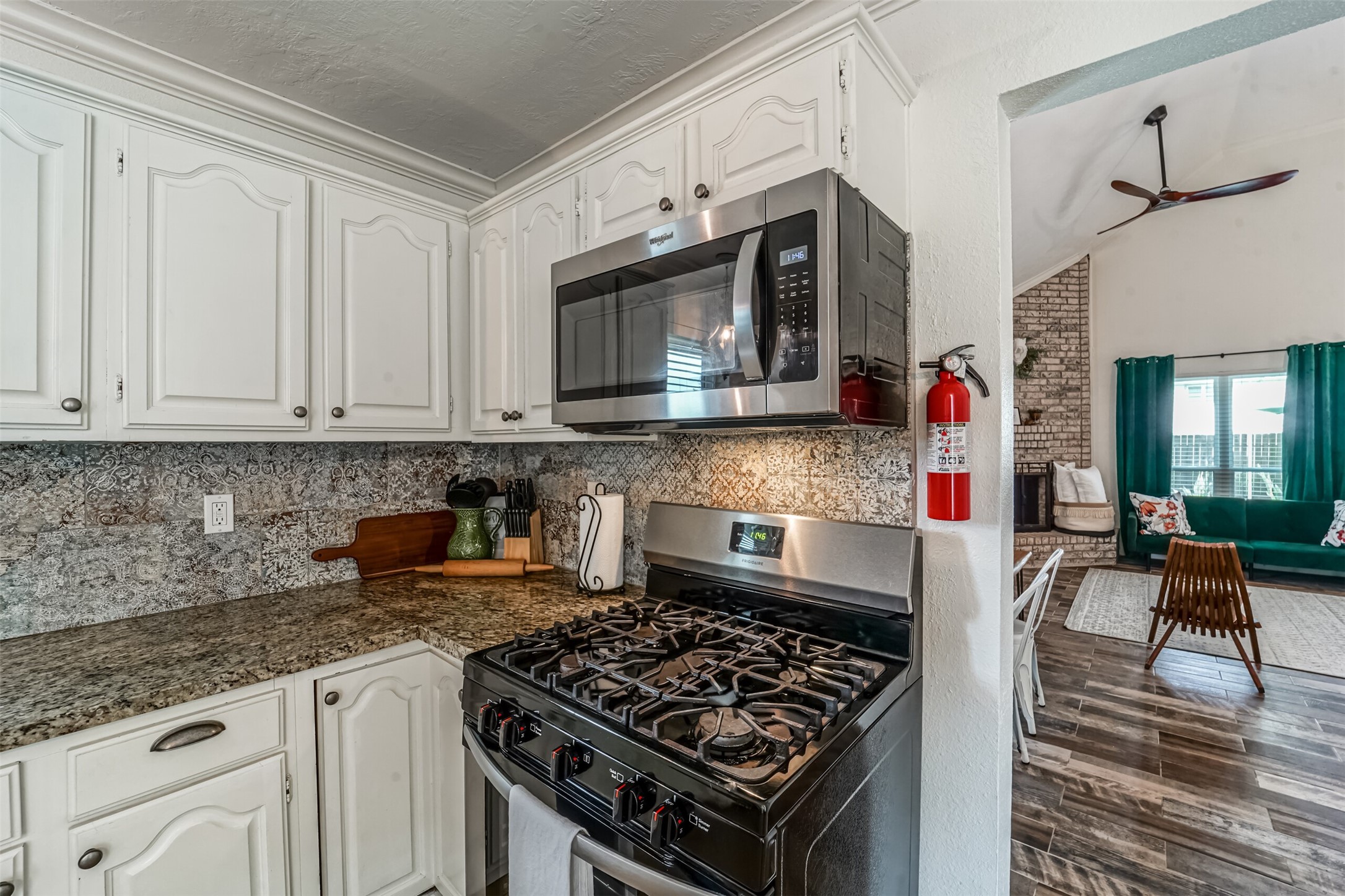 718 Regency Court Friendswood, TX 77546 - Photo 8 of 21 Stove with 5 burner gas cooktop, and microwave. This kitchen has plenty of cabinets which are stocked with all essential pots pans and dishes. Move in ready!