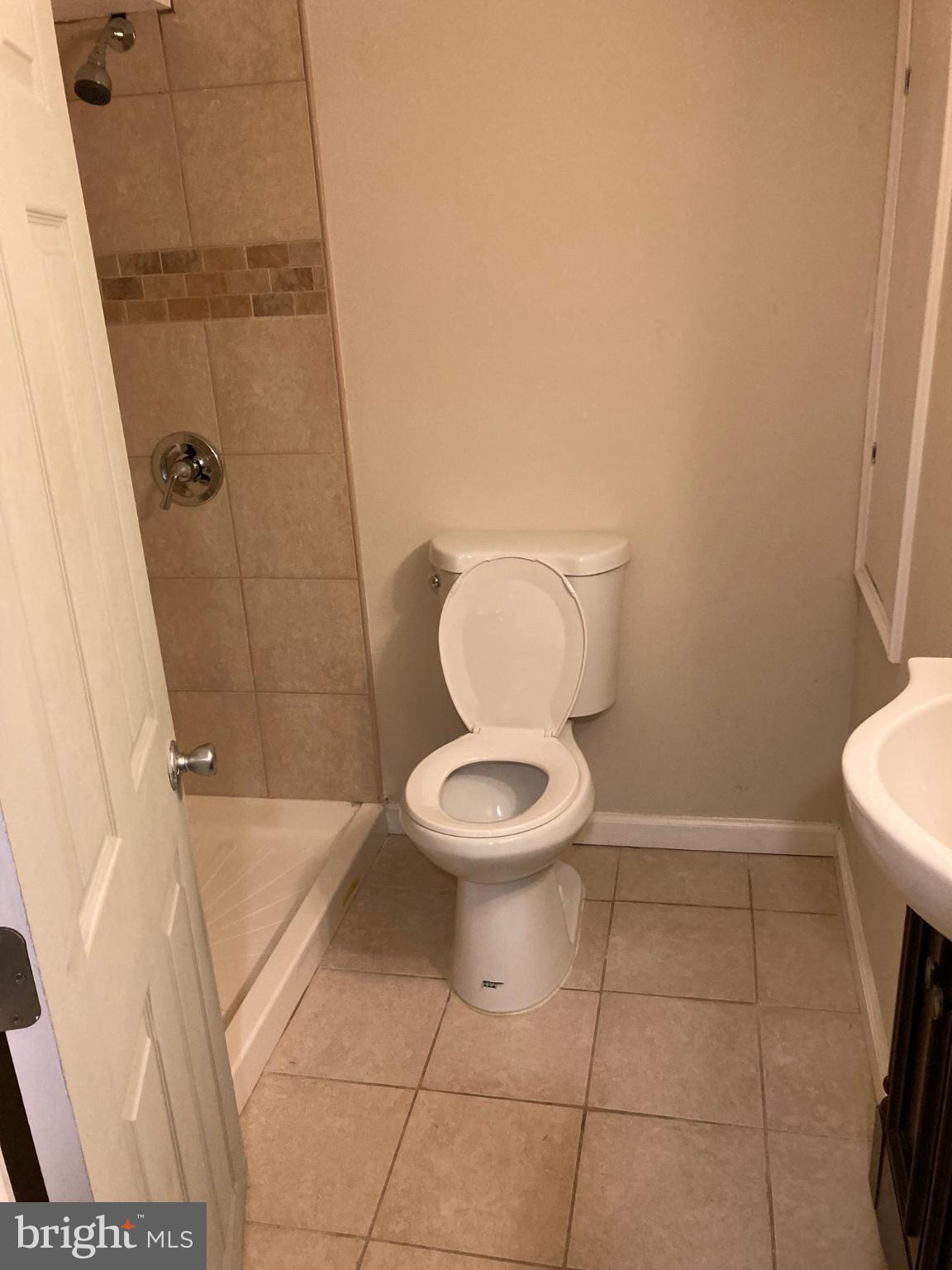 1213 West Old Cold Spring Lane Baltimore, MD 21211 - Photo 13 of 15 a bathroom with a toilet and a shower