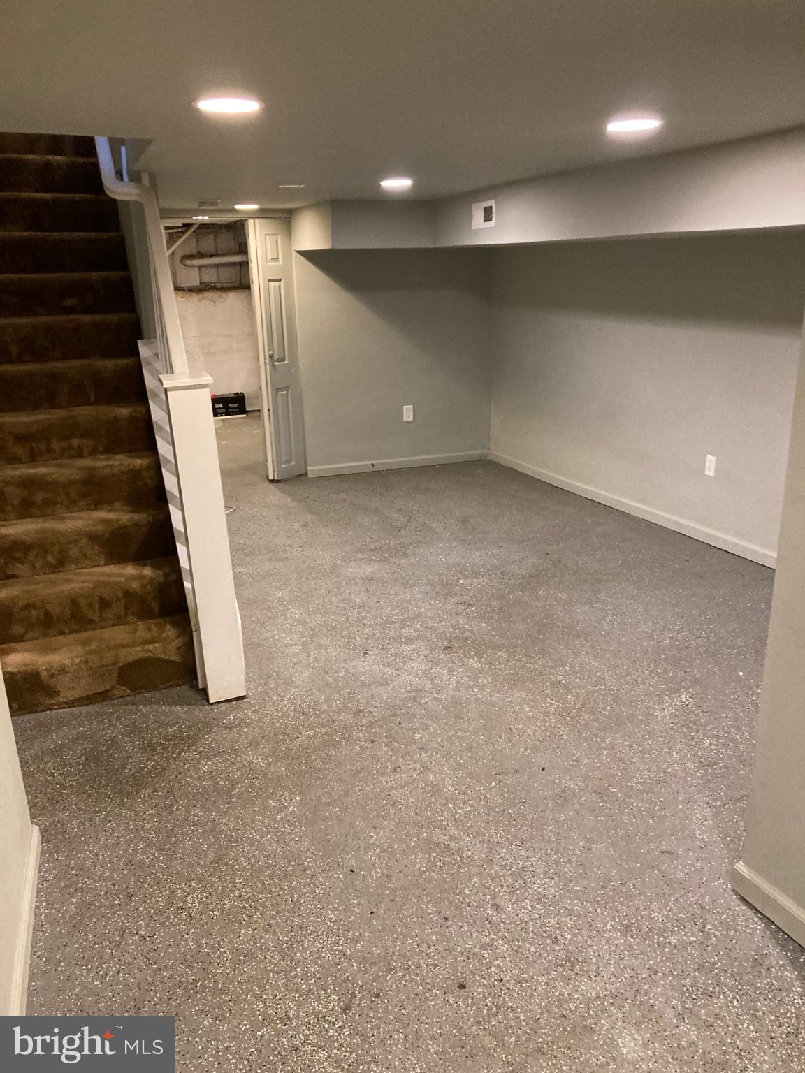 1213 West Old Cold Spring Lane Baltimore, MD 21211 - Photo 14 of 15 an empty room with wooden floor and stairs