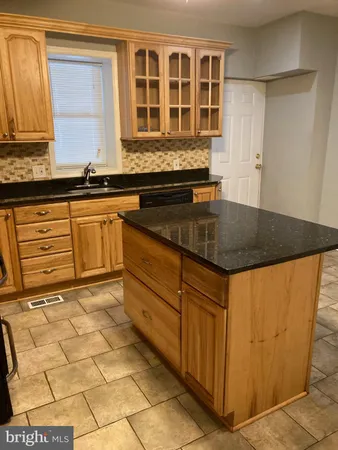 a kitchen with granite countertop a sink and a stove