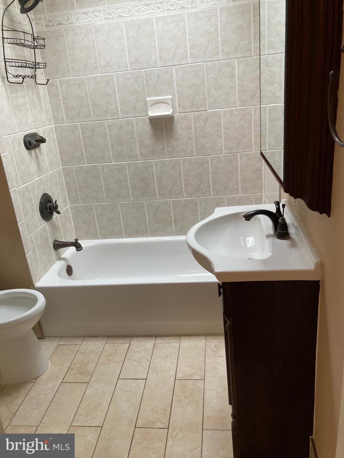 1213 West Old Cold Spring Lane Baltimore, MD 21211 - Photo 9 of 15 a bathroom with a sink a toilet and bathtub