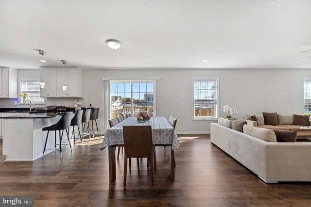 a living room with furniture and a dining table with wooden floor