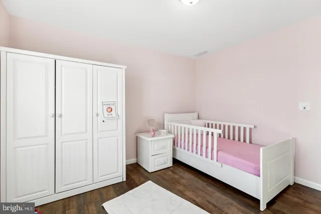 a bedroom with a white bed and wooden floor
