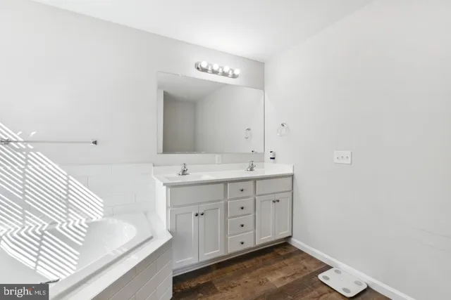 a spacious bathroom with a double vanity sink and a mirror