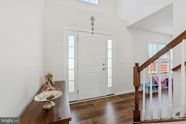 a hallway with wooden floor chandelier and entryway