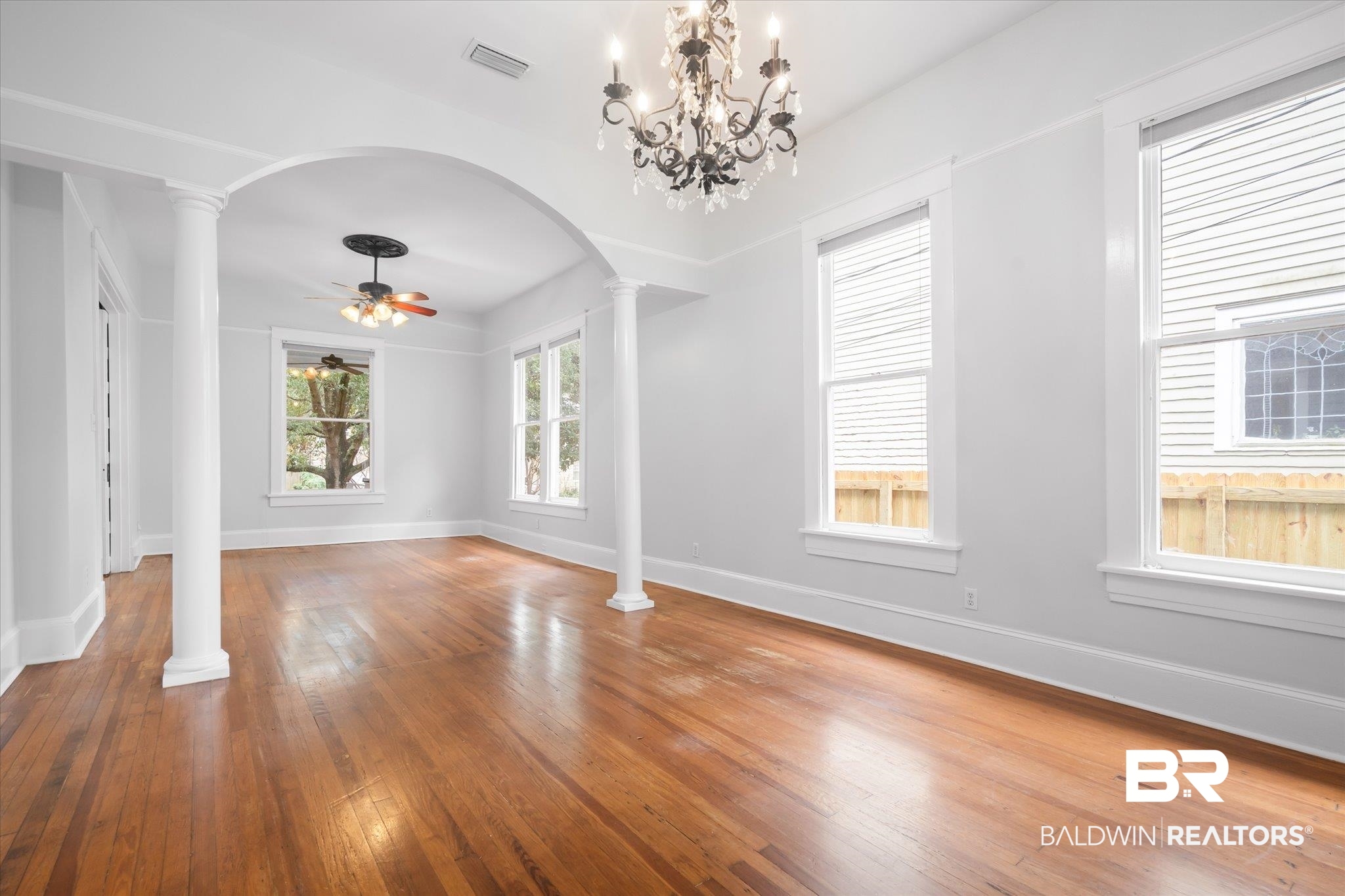 14 South Monterey Street Mobile, AL 36604 - Photo 6 of 41 Interior space featuring hardwood / wood-style flooring, ornate columns, and ceiling fan with notable chandelier