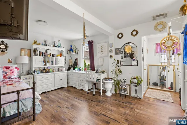 a large white painted room with furniture and wooden floor