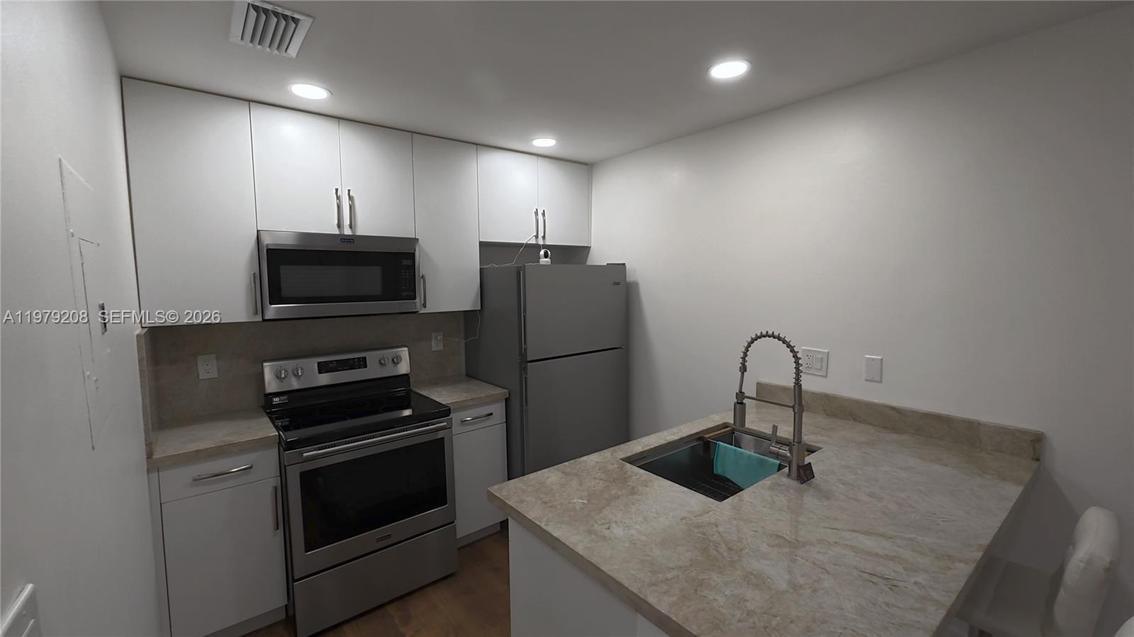 7121 Southwest 129th Avenue, Unit 8 Miami, FL 33183 - Photo 5 of 13 a kitchen with sink a microwave and refrigerator