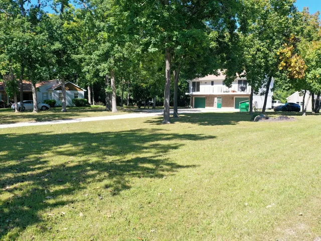 a front view of a house with a yard and trees