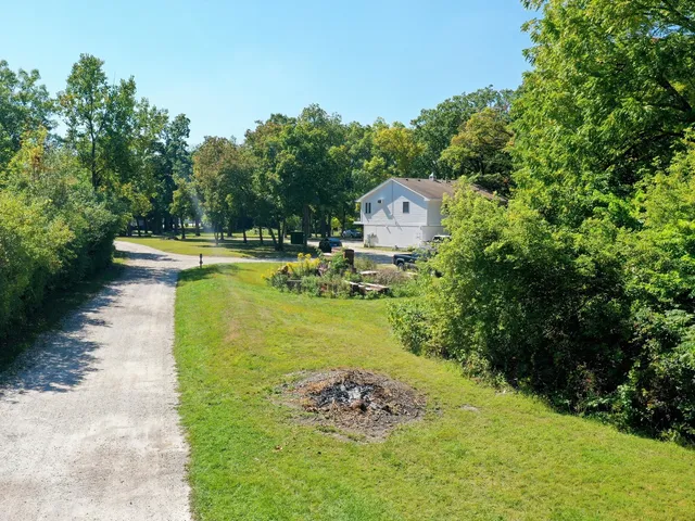a view of a swimming pool with lawn chairs under an umbrella
