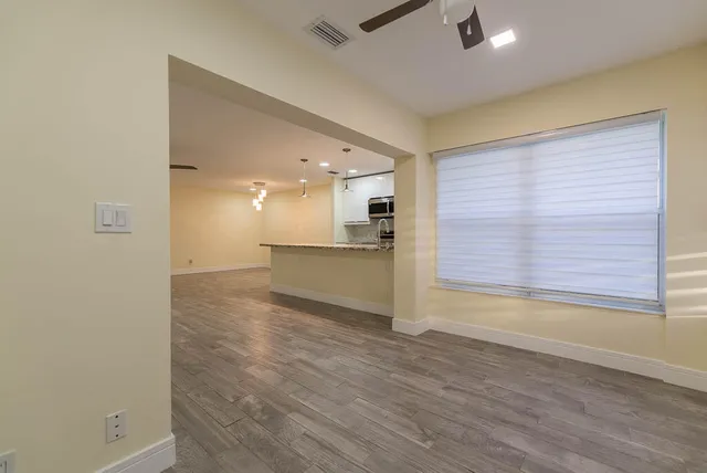 a large kitchen with a center island and wooden floor
