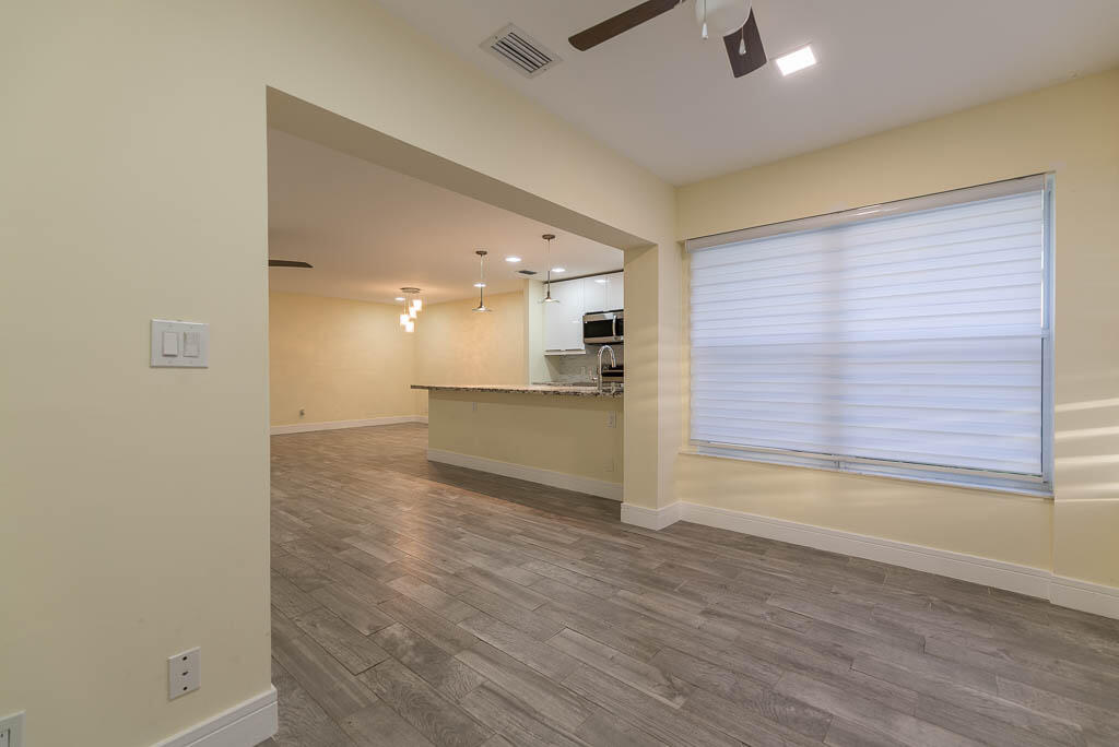 14250 Nesting Way, Unit B Delray Beach, FL 33484 - Photo 11 of 45 a view of kitchen and empty room with wooden floor