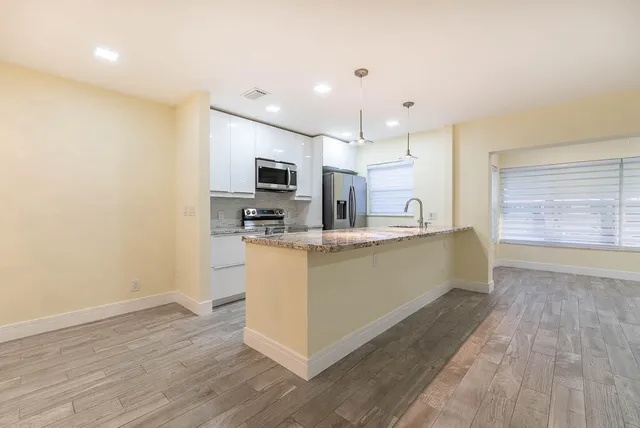 a kitchen with stainless steel appliances granite countertop a sink a stove and a refrigerator