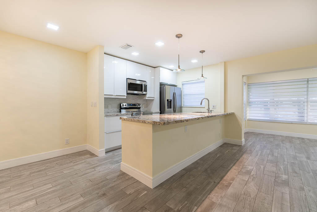 14250 Nesting Way, Unit B Delray Beach, FL 33484 - Photo 12 of 45 a large kitchen with a center island and wooden floor